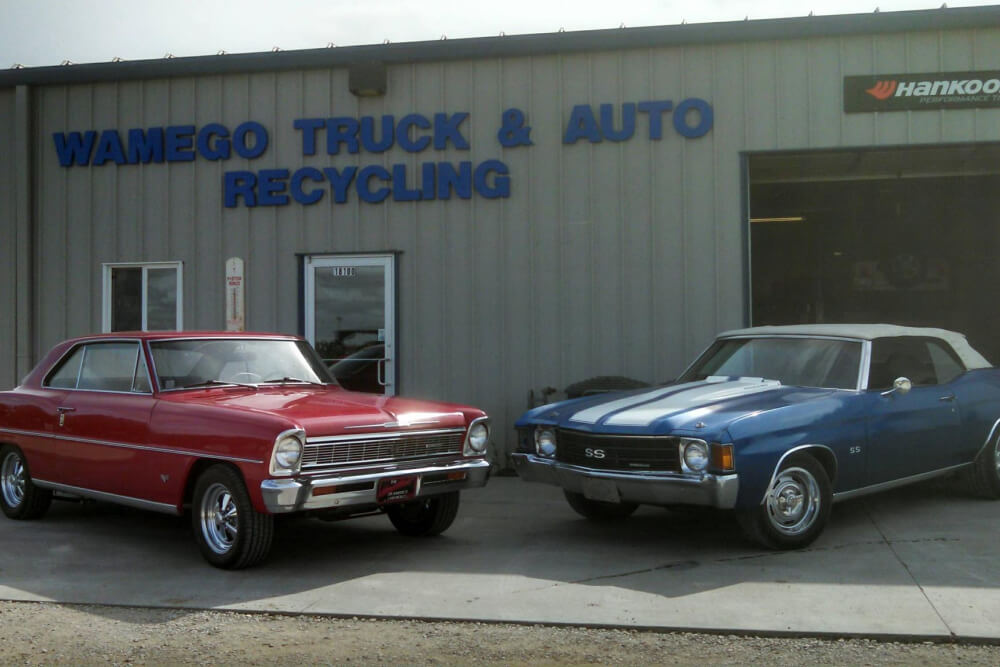 Two cars in front of Wamego Truck & Auto Recycling Shop